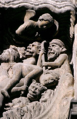 A sculpture including statues of goblins decorates the south porch of The Cathedral of Notre Dame,  France.