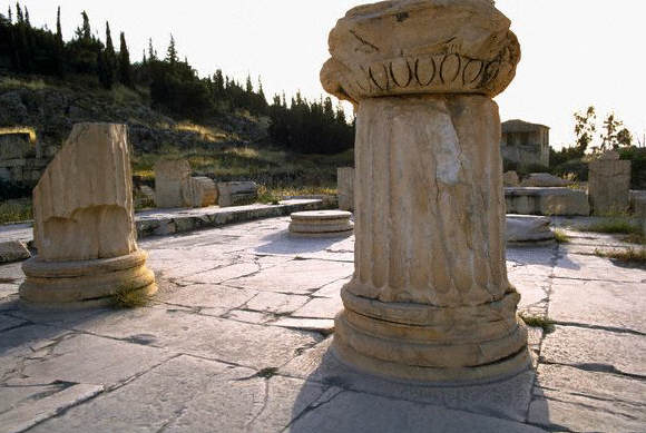 Fragmentary columns on a worn stone pavement flank the propylea, or entrance to the sacred area, at the ruins of Eleusis