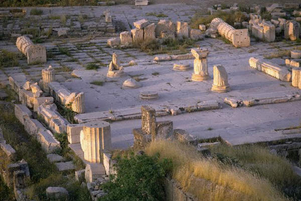 Fragmentary columns on a worn stone pavement flank the propylea, or entrance to the sacred area, at the ruins of Eleusis