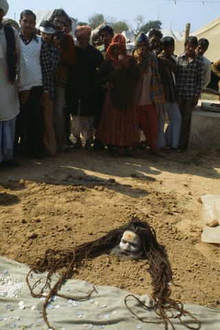 A sadhu buries his body in sand during a solar eclipse ceremony in Kurukhshtra